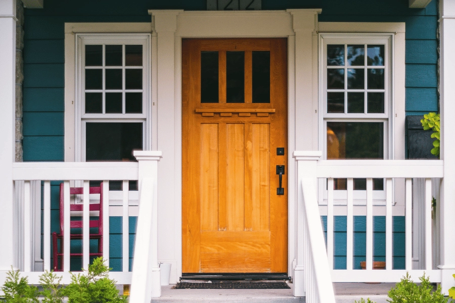light brown front door and front porch in a suburban neighborhood